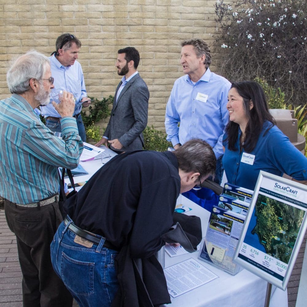 people talking at solar panel installation promo table