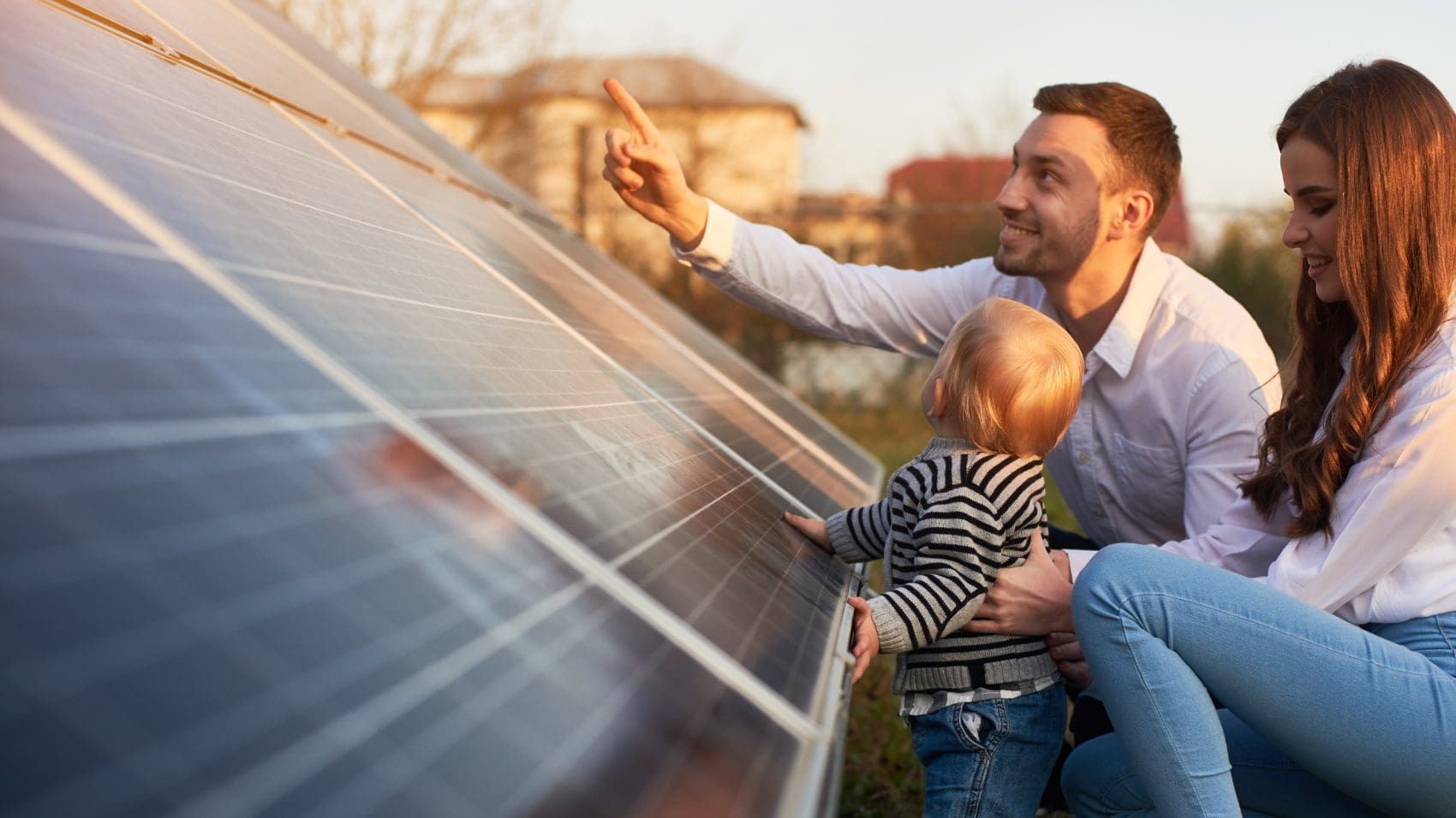 young family in front of solar panels