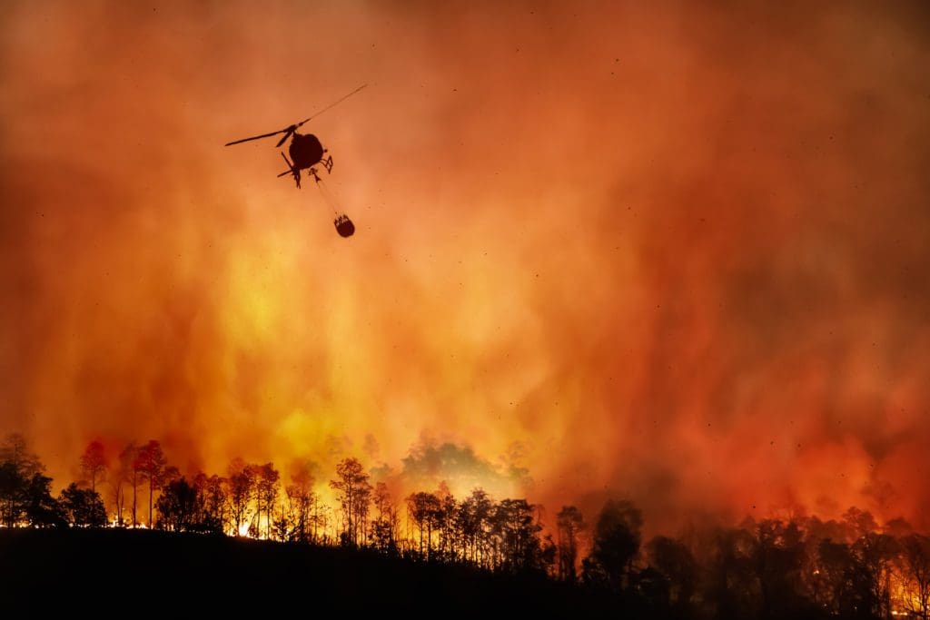 helicopter hovering over wildfire