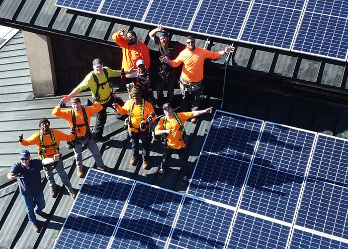solar panel workers waving to camera
